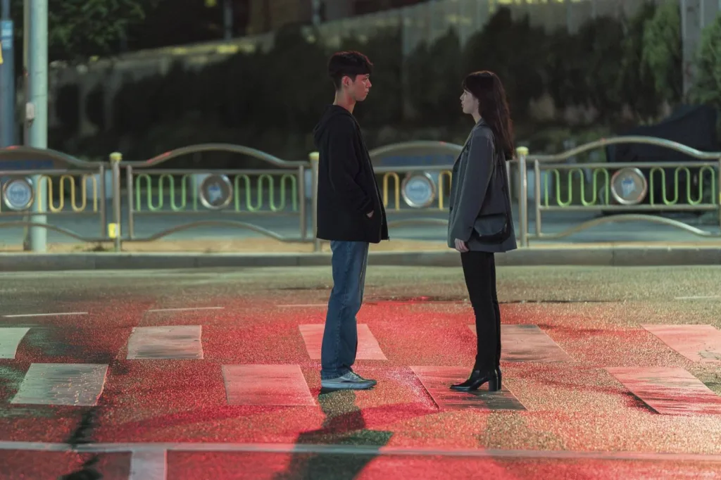 A man and a woman in casual look facigng each other standing. Still from the movie Wonderland