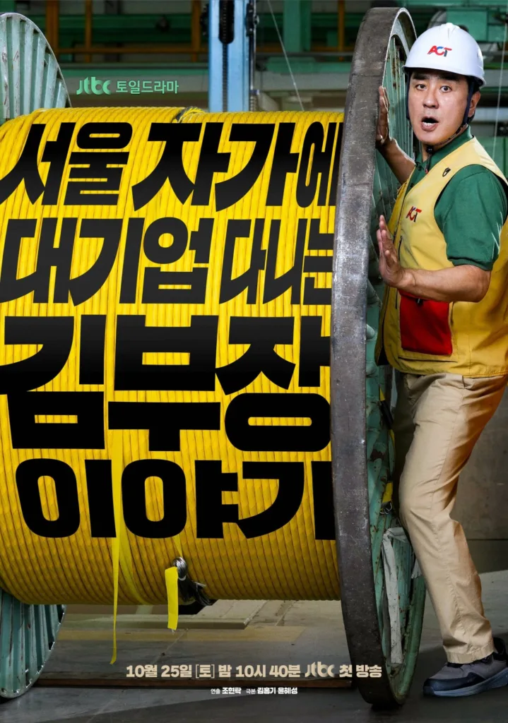 Promotional poster for the JTBC “Towel Drama” series “서울 자가에 대기업대는 김부장 이야기” (Seoul Jaga-e Daegib Dae-neun Kim Bujang Iyagi / The Story of Manager Kim, Who Runs a Big Corporation from His Seoul Home). A middle-aged man in a green work shirt, yellow safety vest, and white hard hat with “ACT” logo stands beside a massive spool of bright yellow industrial cable. He leans against the spool with a surprised or playful expression, mouth open as if caught mid-speech. The bold black Korean title is overlaid across the cable spool. At the top left: “JTBC 토일드라마” (JTBC Saturday-Sunday Drama). At the bottom: “10월 25일 [토] 밤 10시 40분 JTBC 첫 방송” (First broadcast October 25, Saturday, 10:40 PM on JTBC), with credits for director Jo Hyun-tak and writers Kim Hong-gi and Yoon Hye-seong. The setting appears to be an industrial warehouse or factory floor.