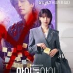 In the foreground, a woman in a tailored gray suit stands confidently, holding a yellow sticky note—her expression calm but resolute. Behind her, a large backdrop features a male idol with a microphone, overlaid with bold red brushstrokes and Korean text: “살인 미소의 내 최애, 살인 사건 용의자가 되다” (“My favorite idol’s deadly smile… becomes the murder suspect”). Scattered across the image are handwritten sticky notes in red and yellow—some with names, others with cryptic phrases—suggesting clues, fan messages, or evidence. The title “아이돌아이” is displayed in large white font at the bottom, with cast names Choi Soo-young and Kim Jae-young listed.